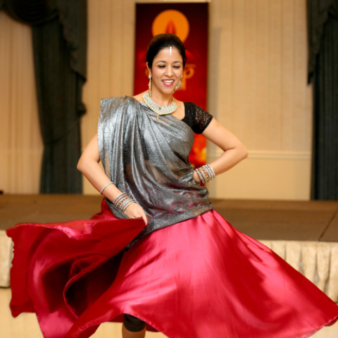 a person in a red skirt dancing on a dance floor