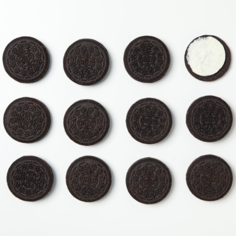 Oreo cookies are arranged in a row on a white surface