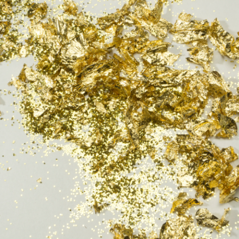 a pile of gold glitter on a white surface