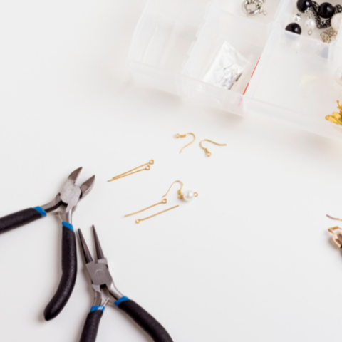 several pairs of earrings and tassels on a white surface