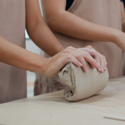 a group of people working on pottery on a table