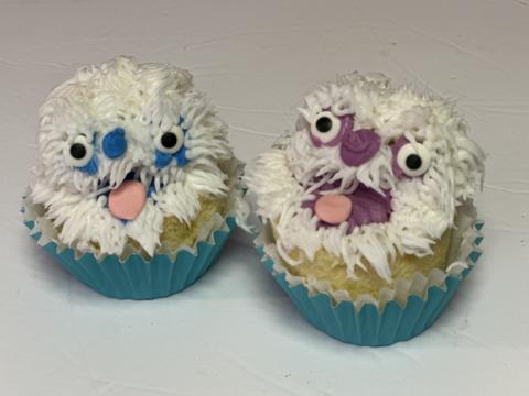 Two cupcakes decorated to look like yetis.