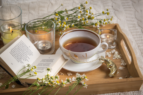 A cup of tea and a book on a tray.