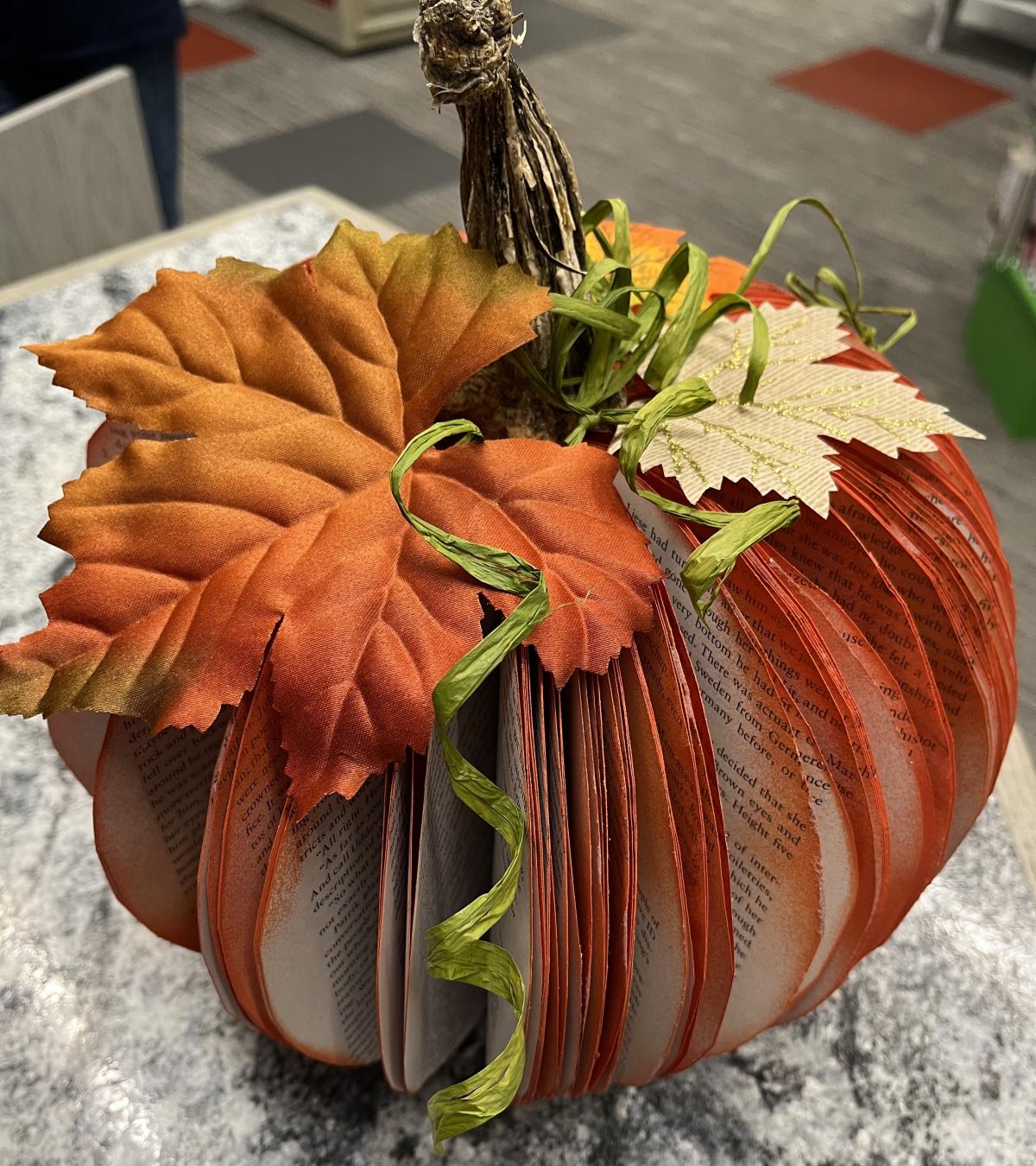 Pumpkin made from a book decorated with faux leaves