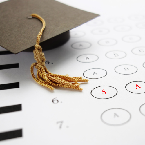a graduation cap sits on top of a test sheet