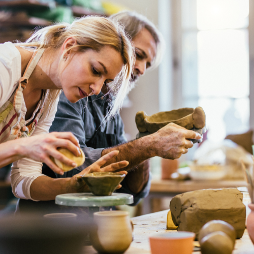 a group of people working on pottery in a studio