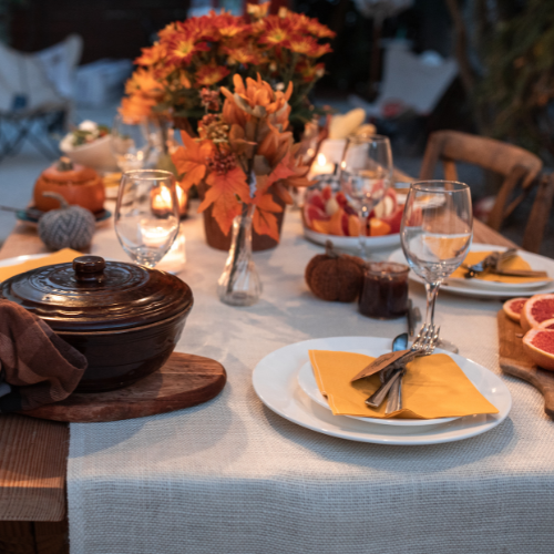 A person is setting up a dinner table for thanksgiving